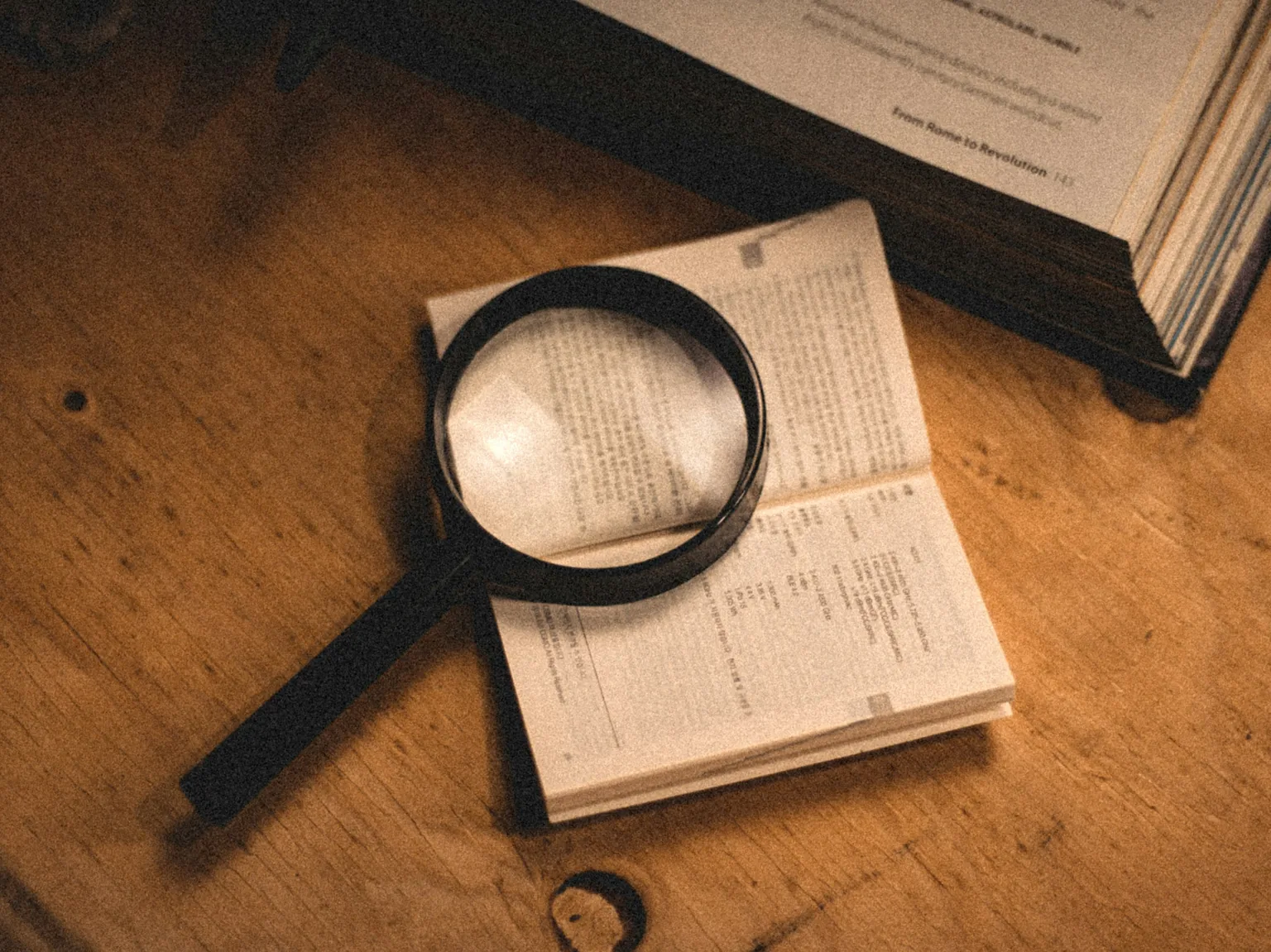 攤開的書上放著放大鏡